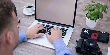 man-with-laptop-and-digital-camera